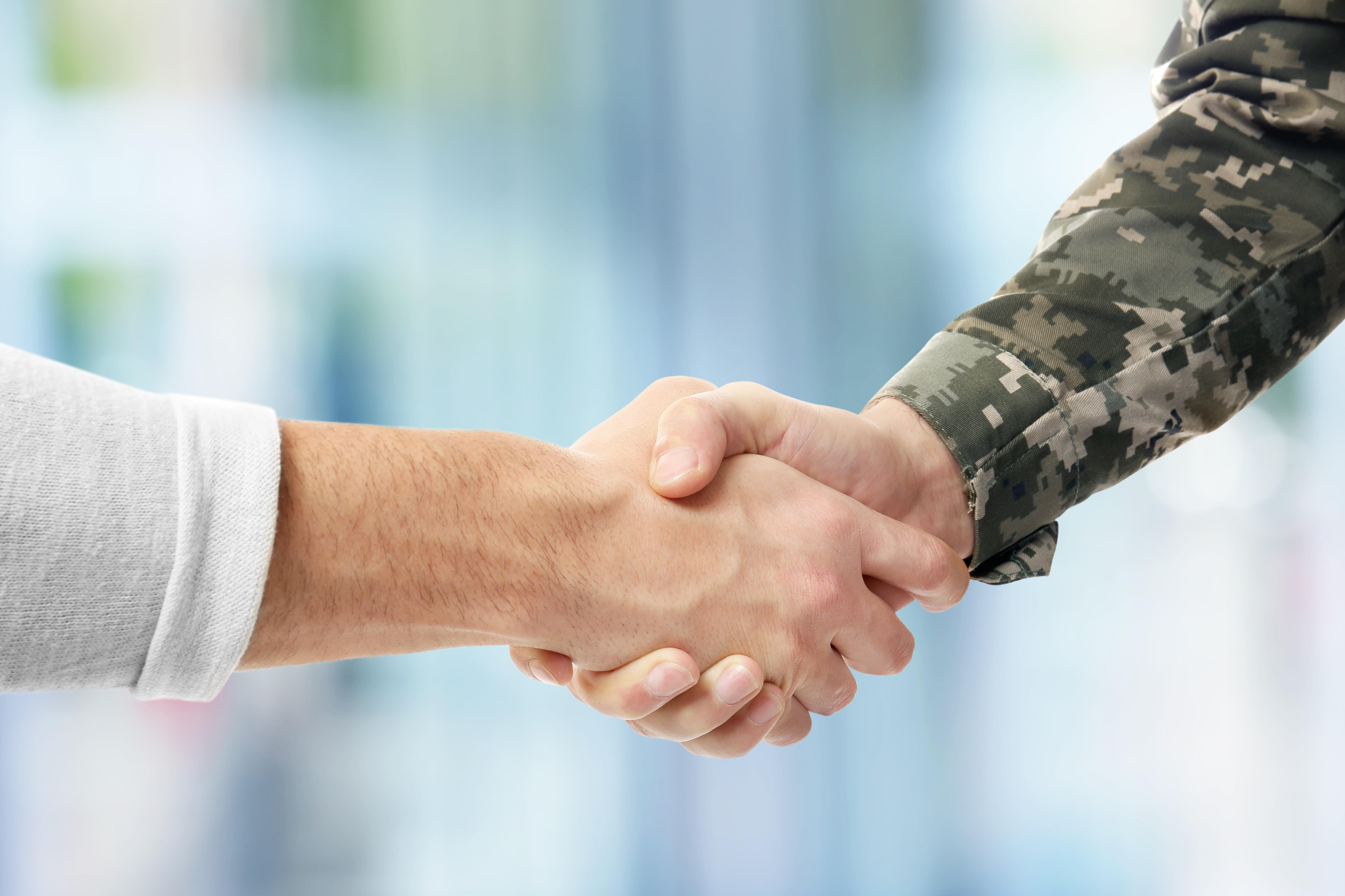 A handshake, with one person wearing military fatigues